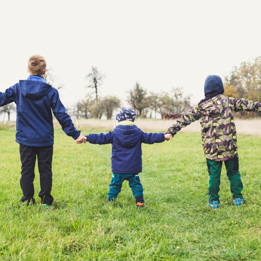 Children holding hands in park